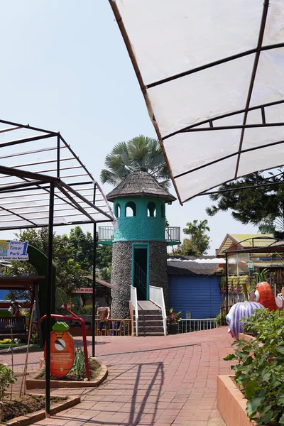 An artificial lighthouse that serves as a boat ride in a theme park