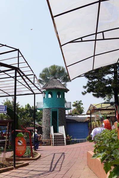An artificial lighthouse that serves as a boat ride in a theme park