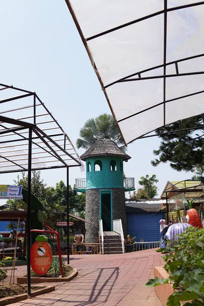 An artificial lighthouse that serves as a boat ride in a theme park