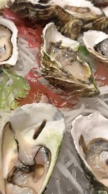 Limonlu taze istiridye, bıçaklı kapak, açık Fransız istiridyesi. Sağlıklı deniz ürünleri. Restoranda Fransız istiridye yemeği. Gurme yemeği, şarküteri. Kenarlık tasarımı, 