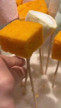 Bir dizi badem kurabiyesi, meyveli tart, marşmelov ve katmanlı sünger keklerle dolu görkemli bir tatlı büfesi, parlak bir pencereye karşı cam raflarda sergileniyor. Marşmelov süngeri.