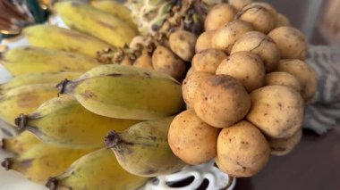 Langsat meyvesiyle elini soyan birinin yakın plan bir fotoğrafı. Langsat meyvesi olarak da bilinen ev yapımı Lancia meyvesi.