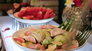 Karpuz, mango, papaya ve ananas da dahil olmak üzere taze dilimlenmiş tropikal meyveler tabakta, sağlıklı beslenme ve yaz içeceğini betimliyor. Sağlıklı Yeme 