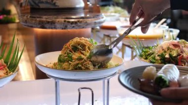 Lüks bir Bali tatil köyü restoranında açık büfe masasında siyah kaselerde servis edilen renkli tropikal salata. Taze sebzeler çok güzel dizilmiş. Yüksek kalite 4k görüntü