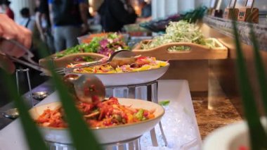 Dikey ekran kadını zarif açık büfe masasında taze salatalar sunuyor. Canlı sebzeler, rahat dekorasyon, yemek atmosferi sağlıklı yemek çeşitleri, leziz yemekler, doğal dokular..