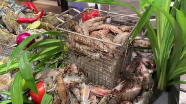 Tedarikçi teraziyi çalıştırırken taze deniz ürünleri ıslak pazar masasında sergileniyor. Çiğ yengeç karides dükkanı