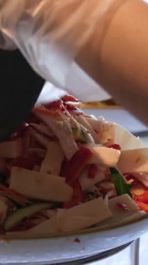 Yavaş çekimde tavukları beyaz kasede taze salataya koyan Sezar Salatası hazırlığı. Yüksek kalite 4k görüntü