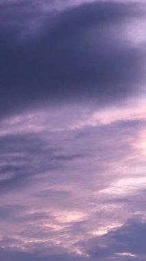 Kabarık tüylü pembe bulutlar uçar gider ve saf günbatımı eflatunu gökyüzü bulutsuz zaman atlaması olarak kalır. Renkli şafak bulutlu gökyüzü bulutsuz mor gökyüzüne dönüşür. Renkli atmosfer gökdelenleri cenneti.