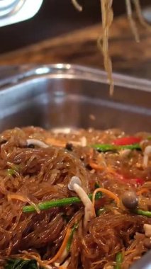 Açık büfe tabak erişteli cam mermerli sebzeli karides ve deniz ürünleri, sebzeler, baharatlar ve koyu beton zemin üzerinde soya soslu cam şehriye. Yüksek kalite 4k görüntü