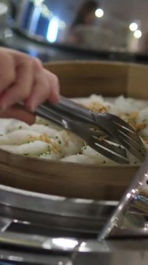 Cruiser 'da büyük bir balık yemeğinin servis edildiği açık büfe sahnesi. Balık, aşındırıcı bir tabağa konmuş sebze ve sosla süslenir. Bir insan balığa servis yapmak için maşa kullanıyor. 