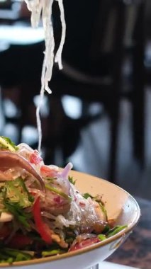 Kore usulü saşimi taze otlar, acı sos ve sarımsakla servis edilir. Lokantalar çiğ balığı marulla sarıp eşsiz, dengeli bir tat için canlı tatlar ekliyorlar. Çiğ gıda konsepti. Yüksek kalite 4k