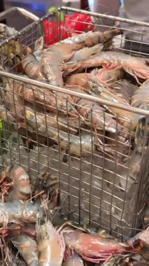 Tedarikçi teraziyi çalıştırırken taze deniz ürünleri ıslak pazar masasında sergileniyor. Çiğ yengeç karides dükkanı