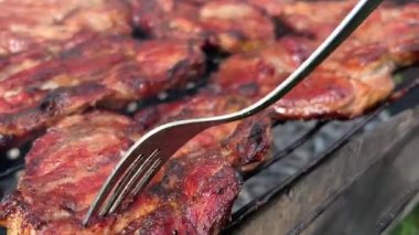 Diğer et ve sosislerle çevrili ızgarada biberiyeyle fırçalanmış sulu biftek bifteği. Ağır çekim. Yüksek kalite 4k görüntü