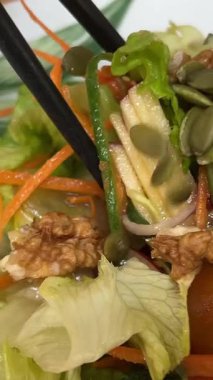 Yeşillikli avokado havuçlu sağlıklı diyet vejetaryen salatası. Elmalar yemek çubuklarını masaya koyar. Yüksek kalite 4k görüntü