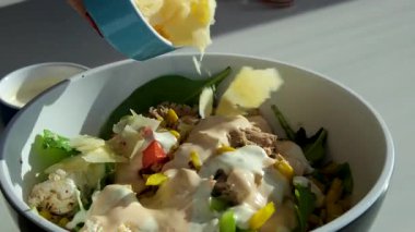 Üzerine parmesan salatası serpiştirilmiş bir şişe zeytinyağı serpiştirilmiş, bir kase taze Yunan salatası yakın plan. Yüksek kalite 4k görüntü