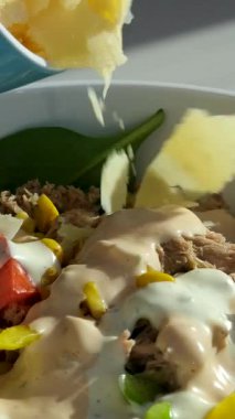 Üzerine parmesan salatası serpiştirilmiş bir şişe zeytinyağı serpiştirilmiş, bir kase taze Yunan salatası yakın plan. Yüksek kalite 4k görüntü