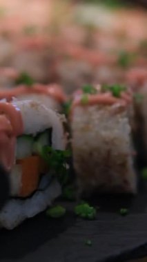 Japon restoranında sushi yiyen Asyalı genç bir kadın. Yüksek kalite 4k görüntü