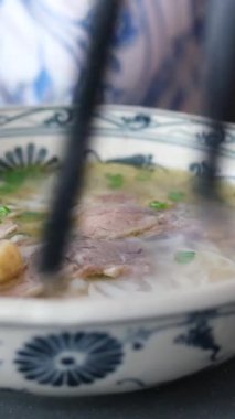 Yeni hazırlanmış Pho Bo erişteleri sığır eti, otlar ve süslemelerle dolu bir kasede servis ediliyor. Yüksek kalite 4k görüntü