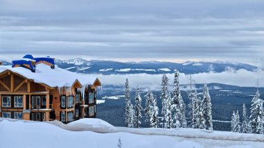 Beyaz Ski Resort, British Columbia bib / Kanada - 29 Ocak 2018: Kelowna yakınındaki popüler kayak beldesinde bir kış günü. Kar ve buz sarkıtları bina ve kar dağların kaplı. 