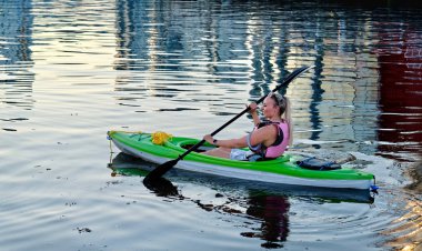 Suda kürek çekmeye kanocu. Genç kadın Vancouver False Creek içinde yaz aylarında kayak. Vancouver. British Columbia. Kanada.