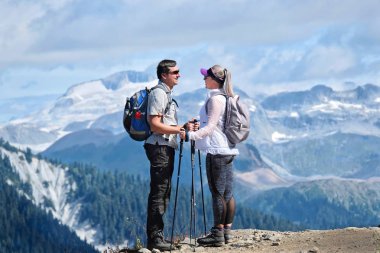 Evli çift dağlarında seyahat. Genç adam ve kadını uçurum güzel manzaralı tutuyoruz. Garibaldi Park Vancouver yakınındaki küçük göl iz. Güzel British Columbia. Kanada.