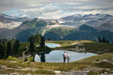 Genç çift yürüyüş güzel alp göller ve buzullar yakınındaki dağlarda evli. Elf göller Whistler Garibaldi Parkı. British Columbia. Kanada.