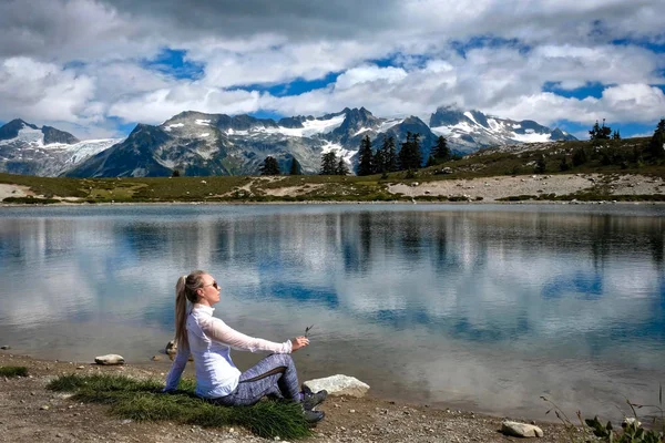リラックスできる湖畔の女性 山と湖の反射の美しい景色 高山草原 ウィスラーの近くにガリバルディ公園で妖精の湖 ブリティッシュ コロンビア州 カナダ — ストック写真