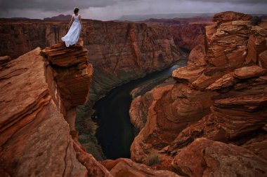Glen Kanyon sarp uçurum üzerinde beyaz elbise duran kadın. At Ayakkabı Bend sayfa yakınındaki. Arizona. Amerika Birleşik Devletleri