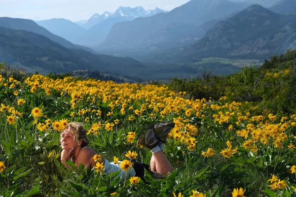 Neopatrná Žena Ležící Mezi Květinami Užívající Slunce Relaxace Květy Arnica — Stock fotografie