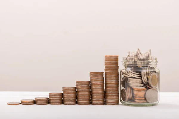 Coin Stack with coin in Glass bottle with free space. Save Coin in Jar isolated on white or gray background. Business concept.