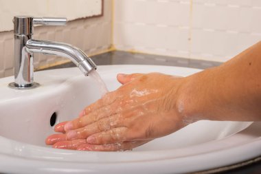 Erkek, Coronavirus 'u (COVID-19) önlemek için önce ve sonra ellerini suyla yıkar..