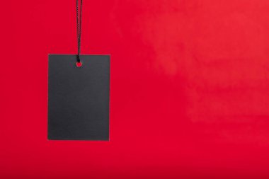 Kara Cuma indirim konsepti. Kırmızı arkaplanda fotokopi alanı ile siyah indirimli etiket rengi.