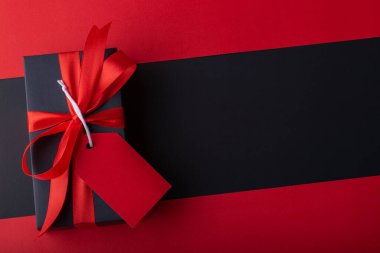 Siyah zemin ve kırmızı zemin üzerinde kırmızı kurdele olan kara kutuların üst görünümü. Kara Cuma ve Boks Günü.