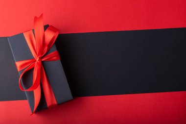 Siyah zemin ve kırmızı zemin üzerinde kırmızı kurdele olan kara kutuların üst görünümü. Kara Cuma ve Boks Günü.