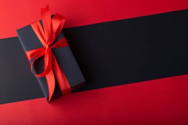 Siyah zemin ve kırmızı zemin üzerinde kırmızı kurdele olan kara kutuların üst görünümü. Kara Cuma ve Boks Günü.