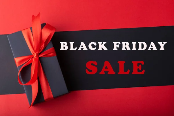 Siyah zemin ve kırmızı zemin üzerinde kırmızı kurdele olan kara kutuların üst görünümü. Kara Cuma ve Boks Günü.