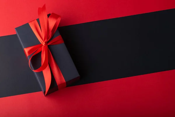 Siyah zemin ve kırmızı zemin üzerinde kırmızı kurdele olan kara kutuların üst görünümü. Kara Cuma ve Boks Günü.