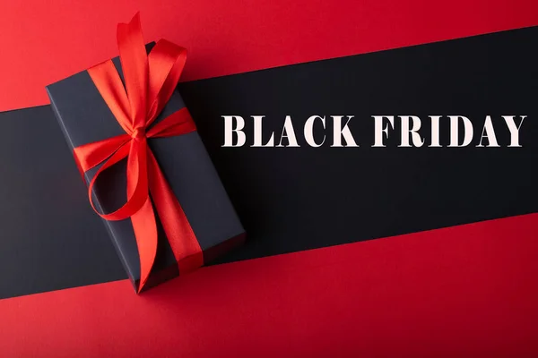 Siyah zemin ve kırmızı zemin üzerinde kırmızı kurdele olan kara kutuların üst görünümü. Kara Cuma ve Boks Günü.