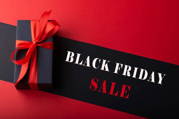 Siyah zemin ve kırmızı zemin üzerinde kırmızı kurdele olan kara kutuların üst görünümü. Kara Cuma ve Boks Günü.