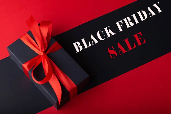 Siyah zemin ve kırmızı zemin üzerinde kırmızı kurdele olan kara kutuların üst görünümü. Kara Cuma ve Boks Günü.