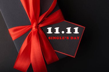 11.11 single 'ın günlük satış konsepti. İnternetten alışveriş konsepti. Siyah arkaplanda şerit ve kopyalama alanı olan siyah ve kırmızı kağıt etiket