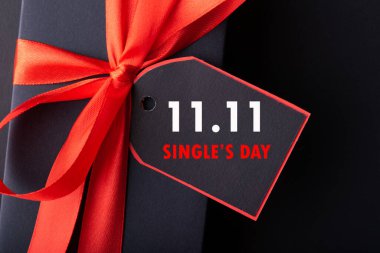 11.11 single 'ın günlük satış konsepti. İnternetten alışveriş konsepti. Siyah arkaplanda şerit ve kopyalama alanı olan siyah ve kırmızı kağıt etiket