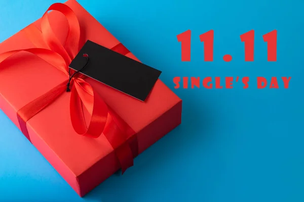 11单身日销售概念 网上购物的概念 红色礼物 带有蓝色背景的黑色标签纸 有复制空间 — 图库照片