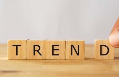 El adamı Trend kelimesini tamamlamaya çalışıyor tahta küp, trend konsepti