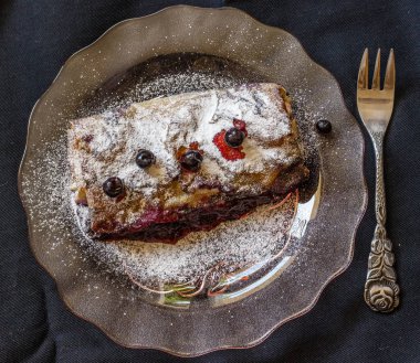 Taze ev yapımı kek, krepteki ek yükü atış karanlık bir arka plan üzerinde cam tabakta pişmiş