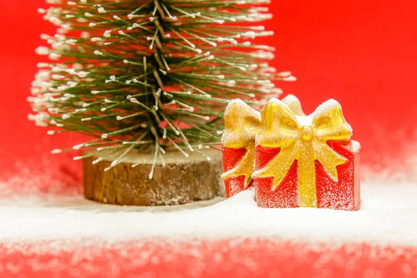 Two Gift Boxes Christmas Tree Covered Snow Red Background Close — Stock Photo, Image