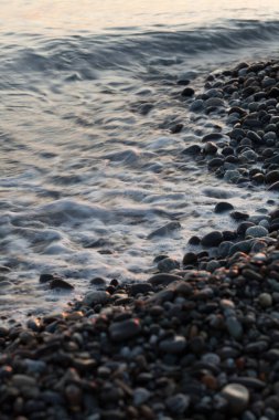 Dalgalar sahildeki kayalara çarpar.