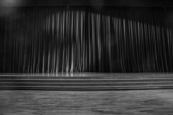 Black and white curtains and wooden stage.
