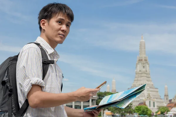 Mężczyzna turystów ubrany w koszulę w kratę trzyma smartfon z — Zdjęcie stockowe