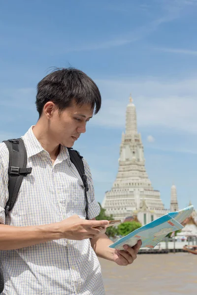 Turistas masculinos vestindo uma camisa xadrez segurando um smartphone com um — Fotografia de Stock